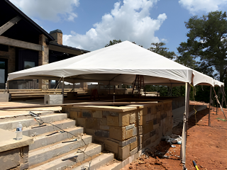 Temporary construction enclosure covering an outdoor work area for weather protection during a residential construction project.