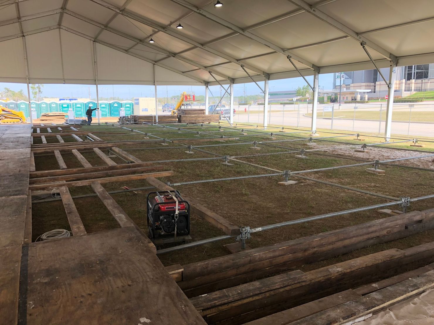 Large construction tent rental providing weather protection, secure storage, and work space at an active Houston construction site.