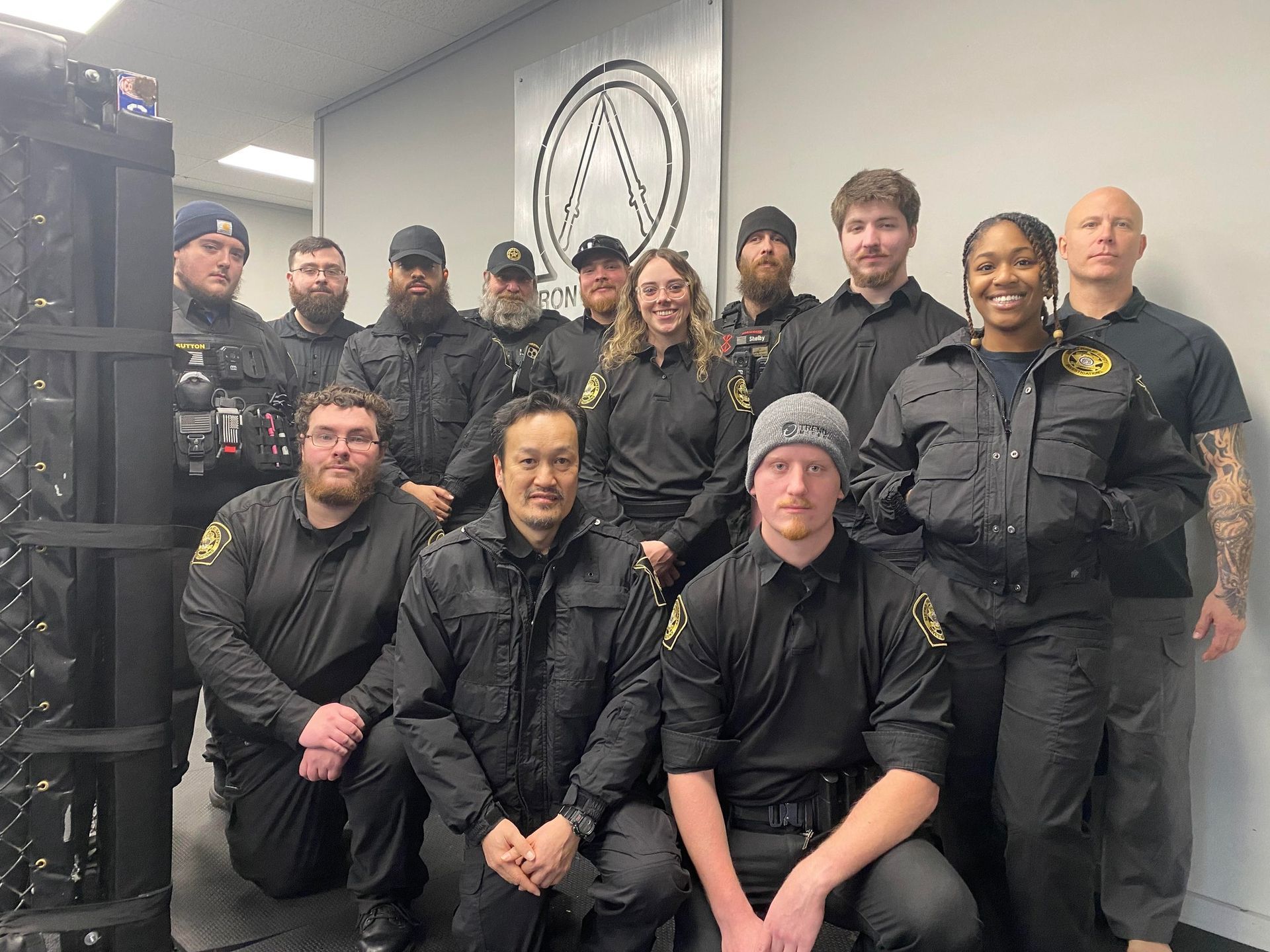 A group of people in black uniforms are posing for a picture.