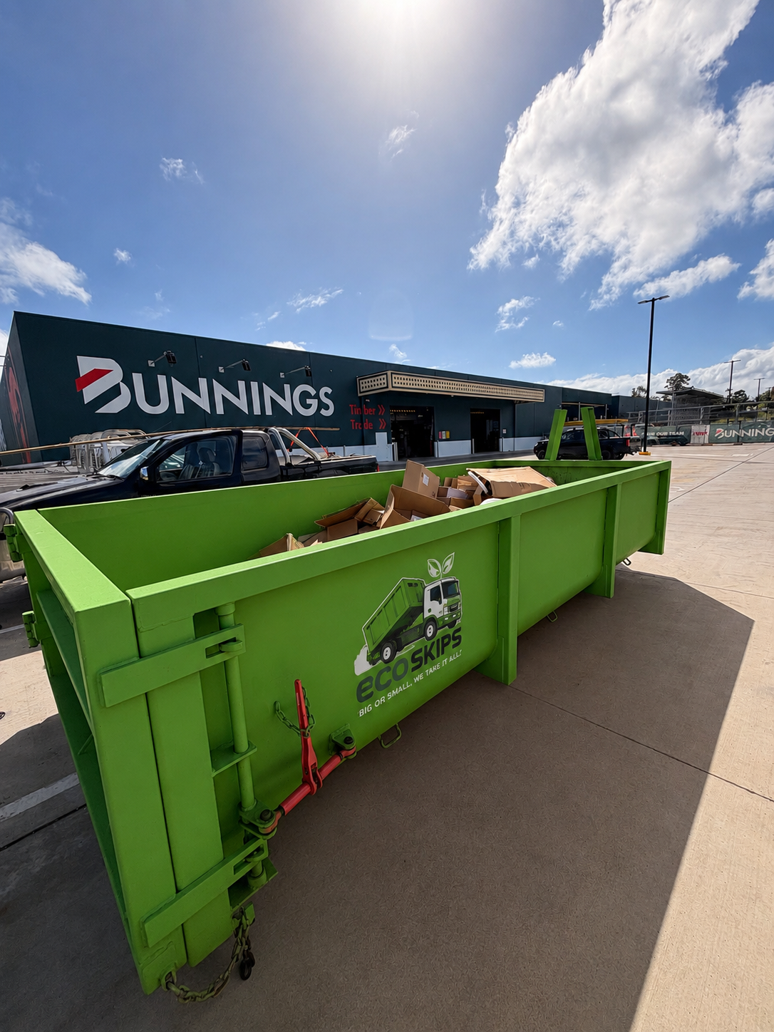 Bright Green Skip Bin Outside Bunnings on a Sunny Day — Eco Skips In Midge Point, QLD