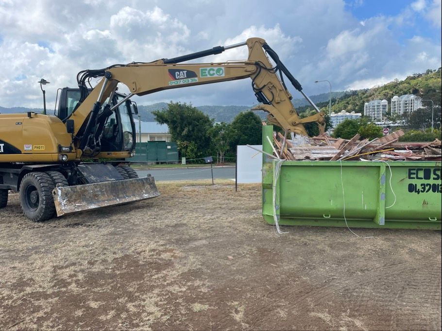 Excavator Dumping Debris Into a Green Dumpster — Eco Skips In Airlie Beach, QLD