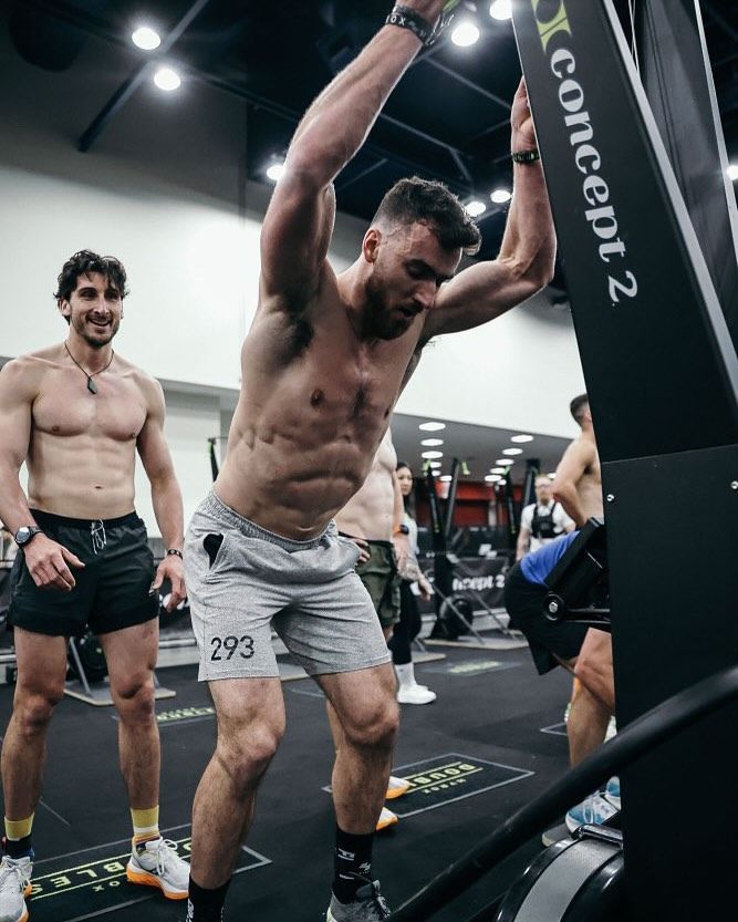 Un groupe d'hommes utilise une machine Concept 2 dans une salle de sport