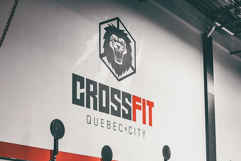 CrossFit Quebec City gym wall logo with a lion emblem in black, white, and red.