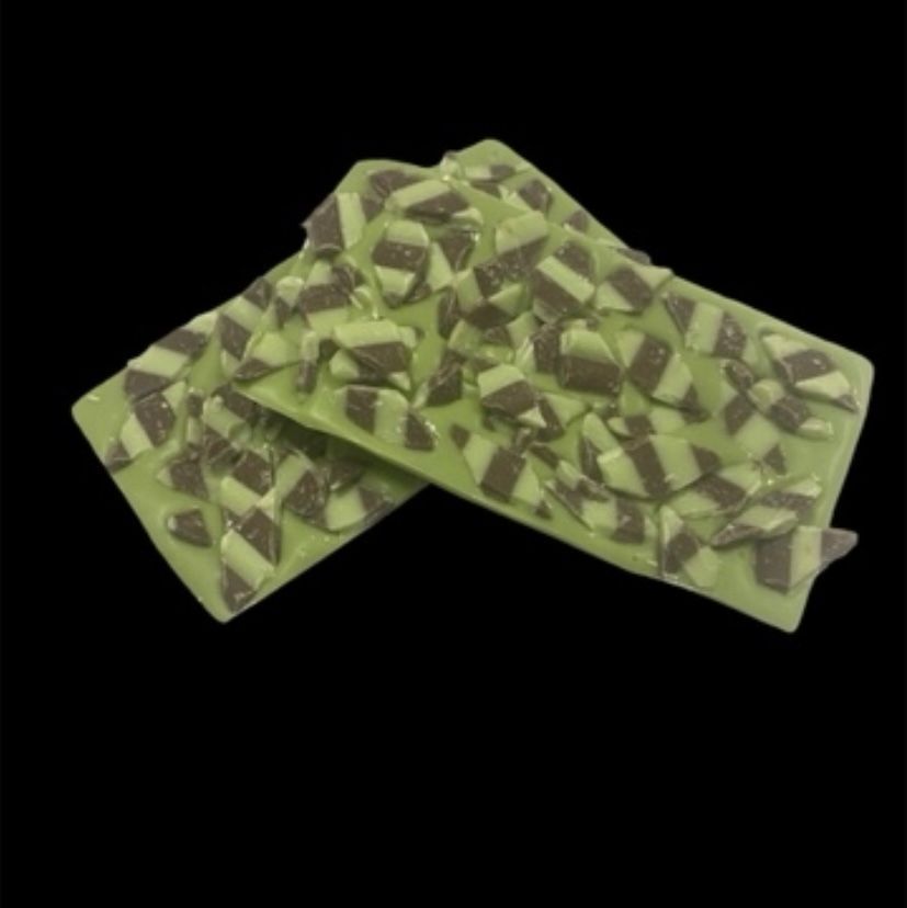 Two green patterned chocolate bars crossed on a black background