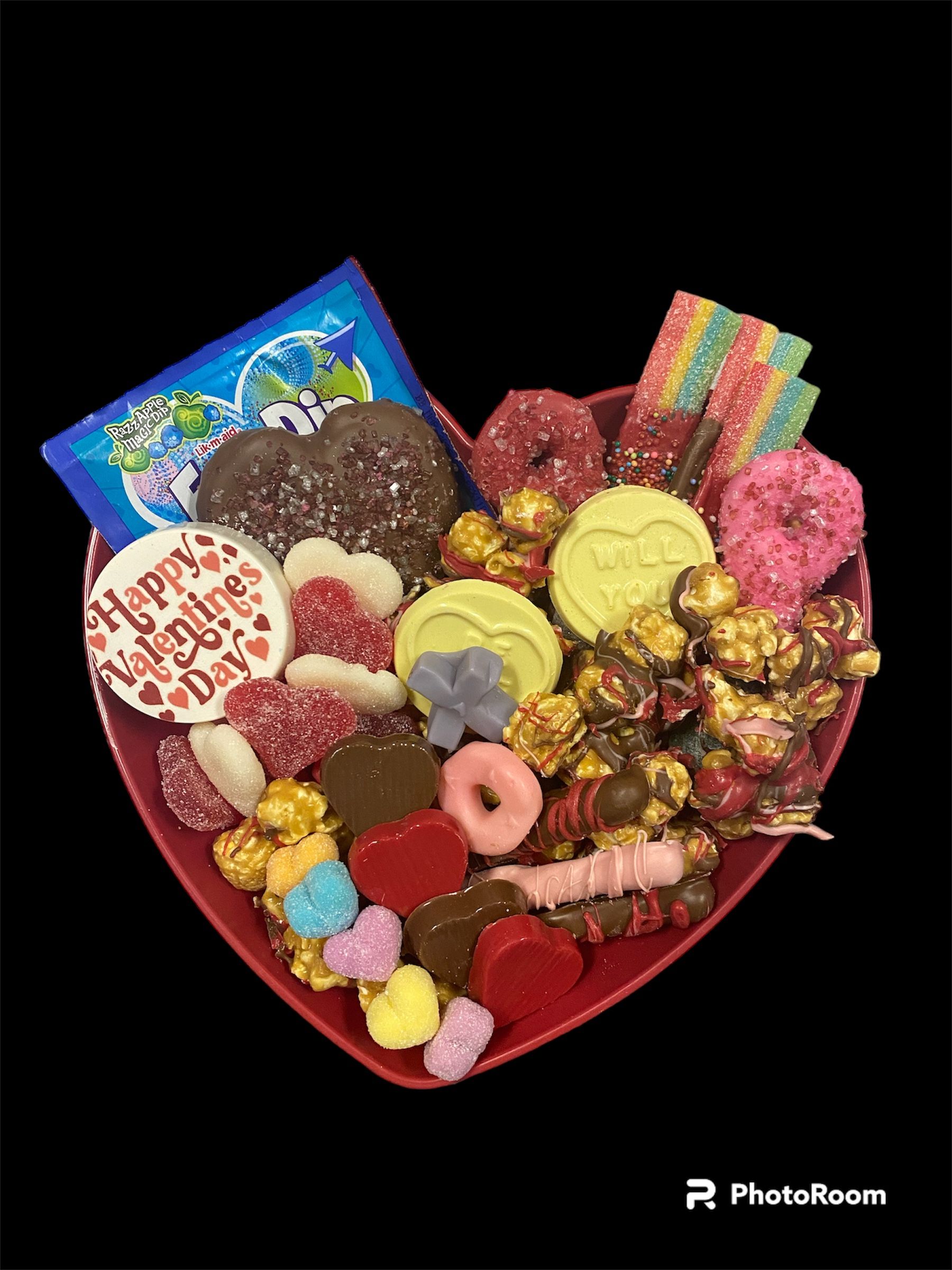 Heart-shaped red gift box filled with colorful assorted chocolates and candies