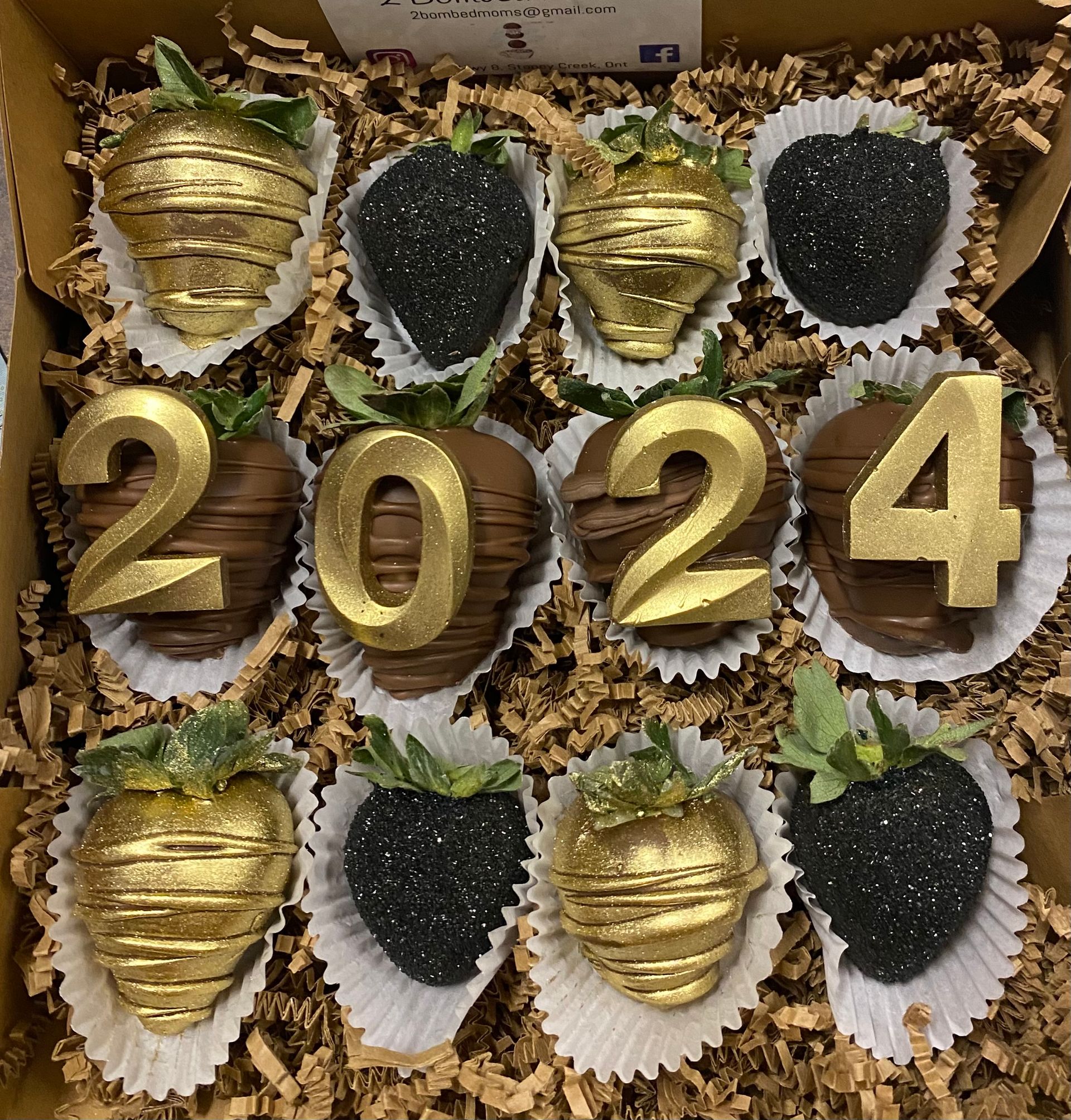 Chocolate-covered strawberries arranged like footballs, mixed with red strawberries and blue and white decorated berries.