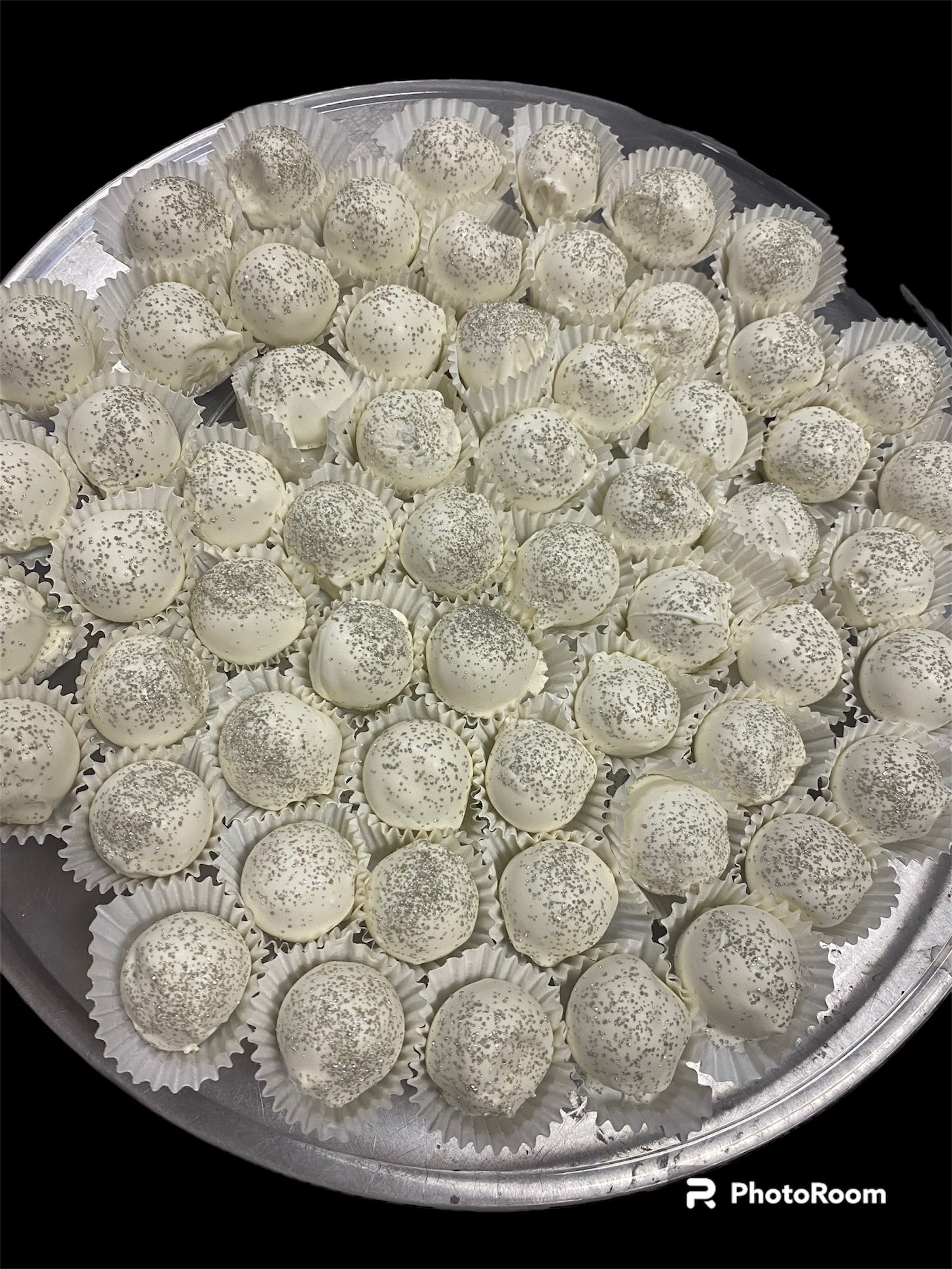 Tray of white coconut-covered dessert balls arranged tightly in a circular pan