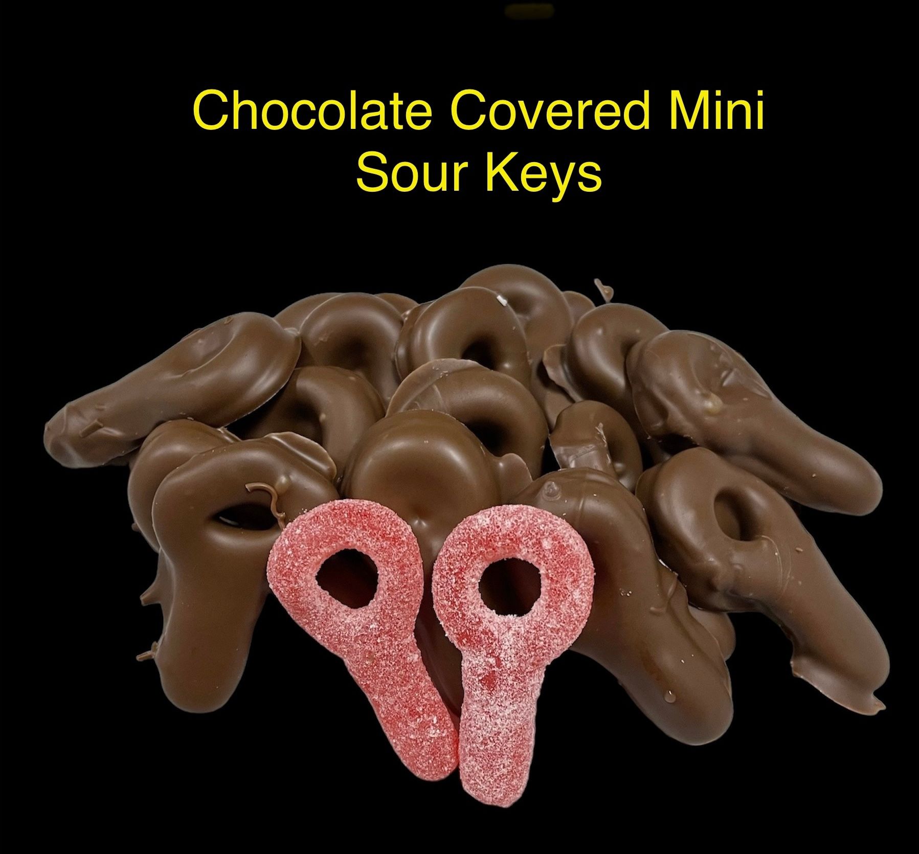 Chocolate-covered mini sour keys in brown and pink, arranged on a black background with the label above.
