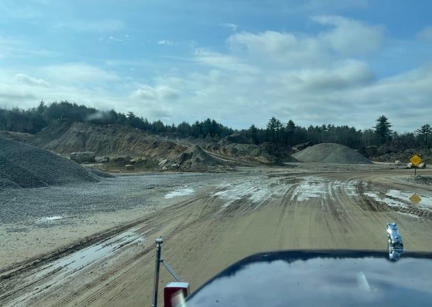 Gravel piles and a muddy road 