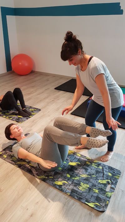 Deux femmes font de l'exercice sur des tapis dans un studio de pilates