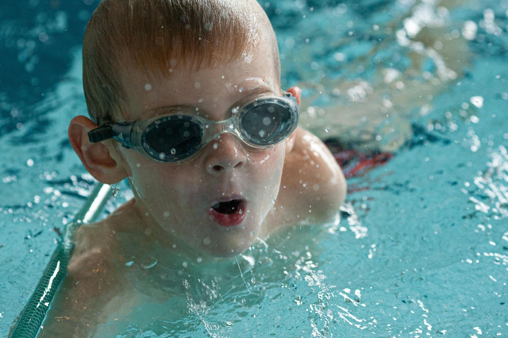 Enfant nageant sous l'eau avec des lunettes de natation dans une piscine