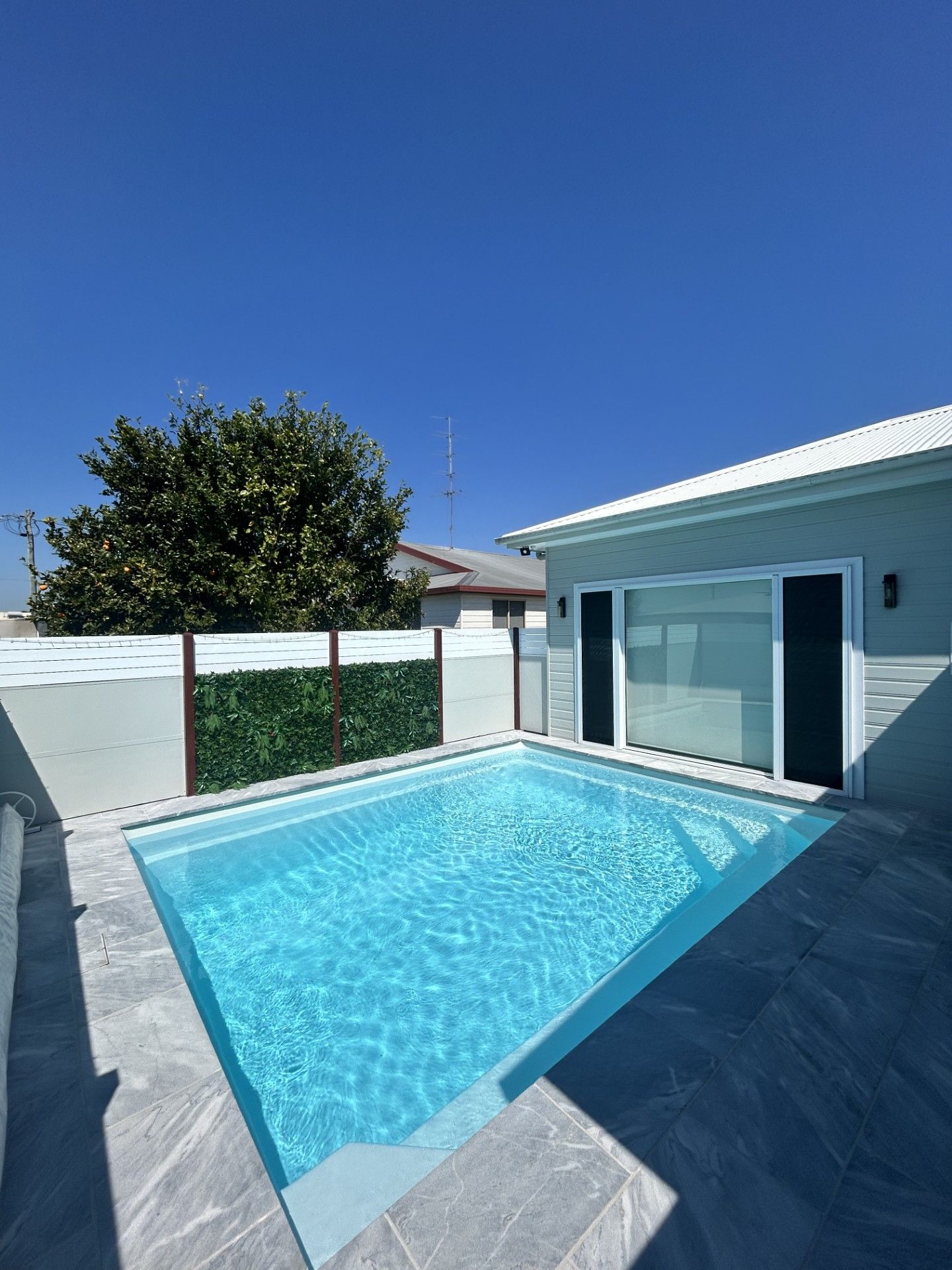 Small backyard pool with blue water next to a house under a clear, blue sky — Clarence Valley Pools In Grafton, NSW