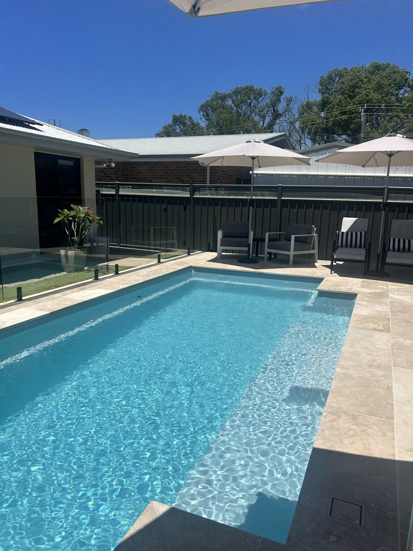 A Modern House With a Swimming Pool With Fibreglass Fence — Clarence Valley Pools In Grafton, NSW