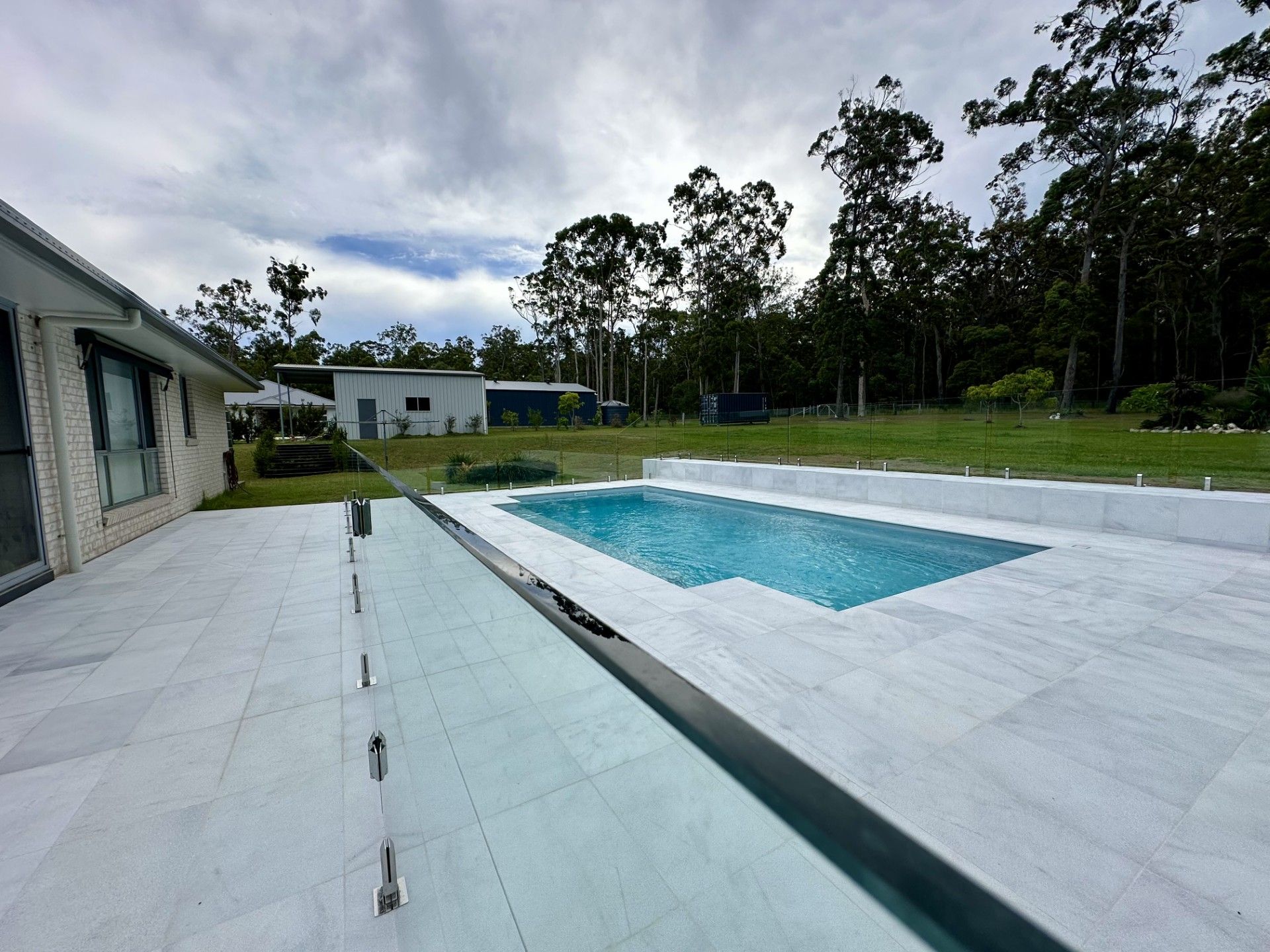 A Modern House With a Swimming Pool and a Wooden Deck  — Clarence Valley Pools In Grafton, NSW