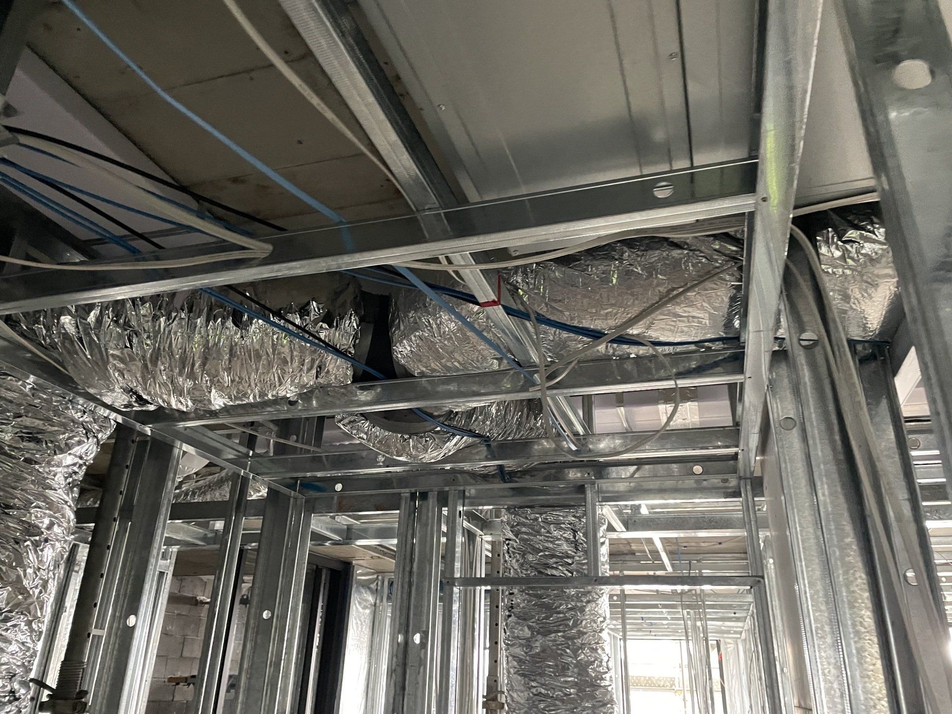 Exposed steel framing and ductwork in an unfinished building interior.