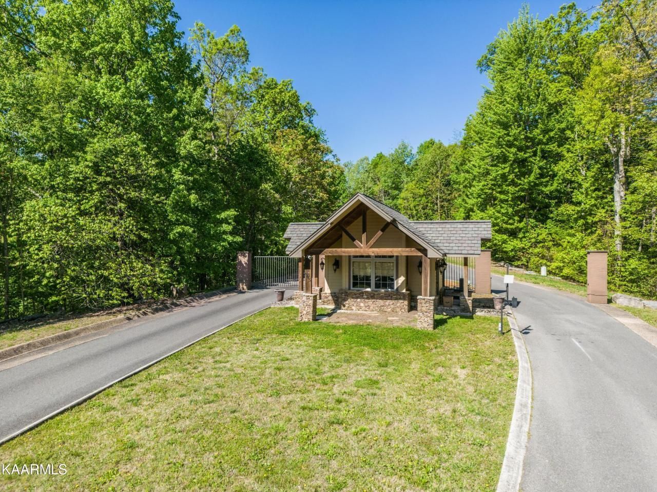 A house sits on the side of a road surrounded by trees