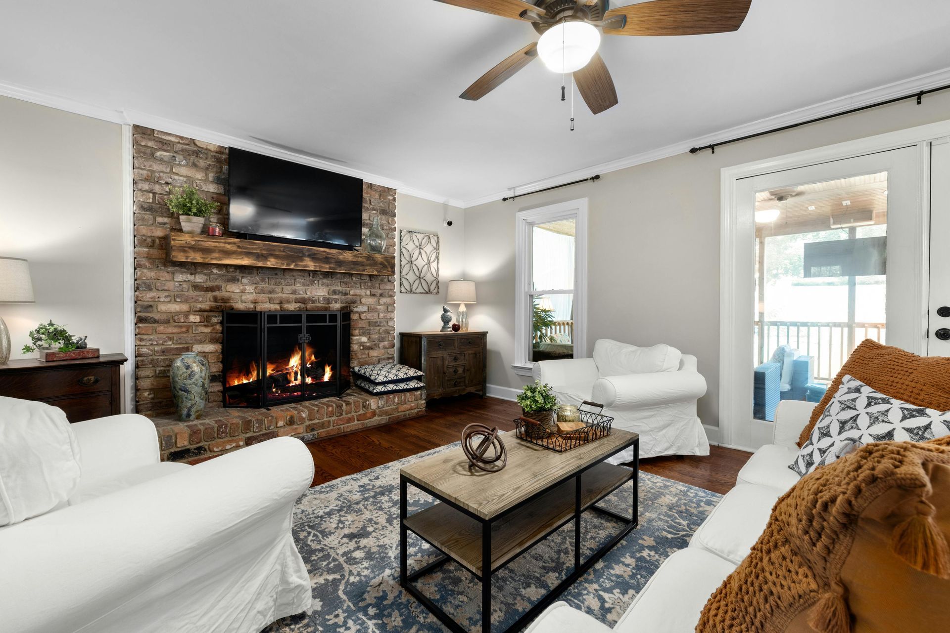 A living room with a fireplace and a flat screen tv.