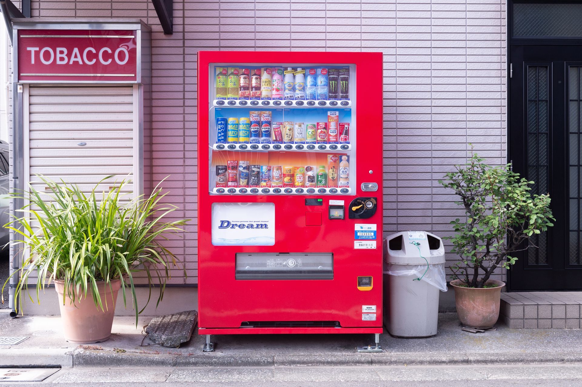 Row of vending machines in a bright indoor lobby with drinks, snacks, and a payment kiosk