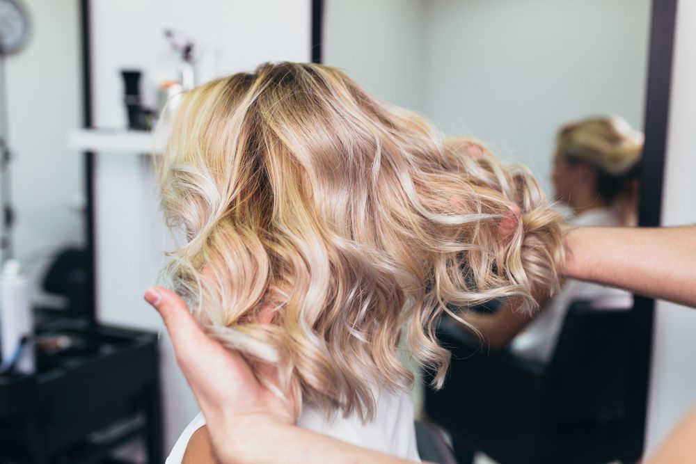 A Woman is Sitting in a Chair at a Hair Salon — Talking Heads Hair Design in Gympie, QLD
