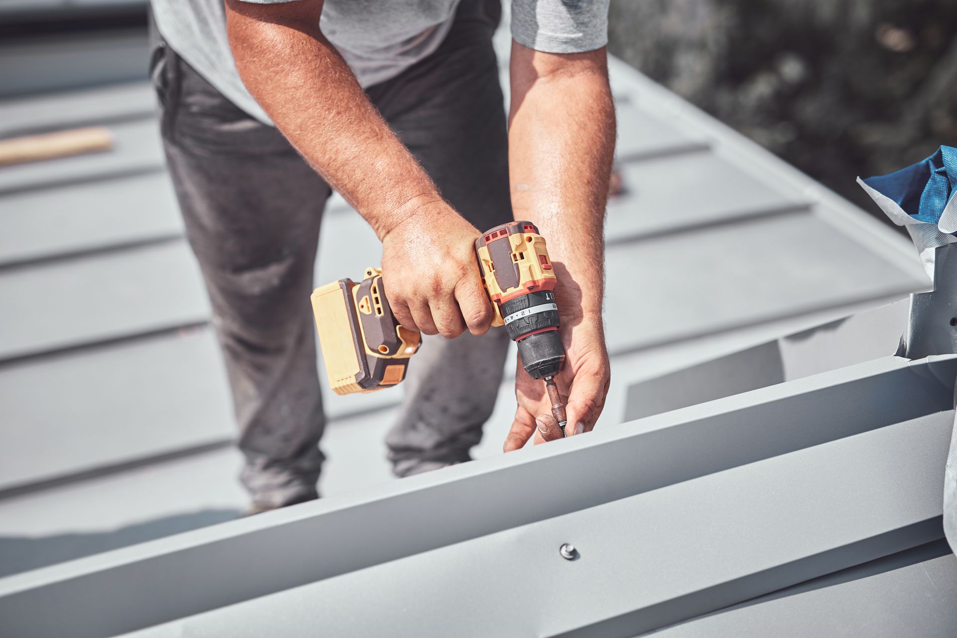 A close-up of a roofer working on a roof replacement and reconstruction