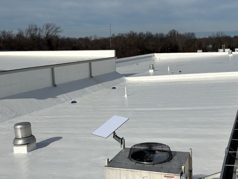 A Starlink satellite dish mounted on a commercial building's white flat roof next to HVAC equipment.