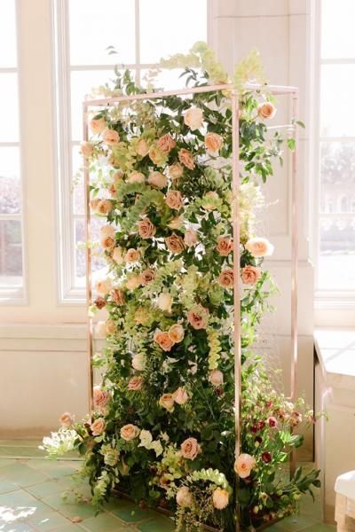 Tall floral arrangement with pink and white flowers in a bright indoor window display