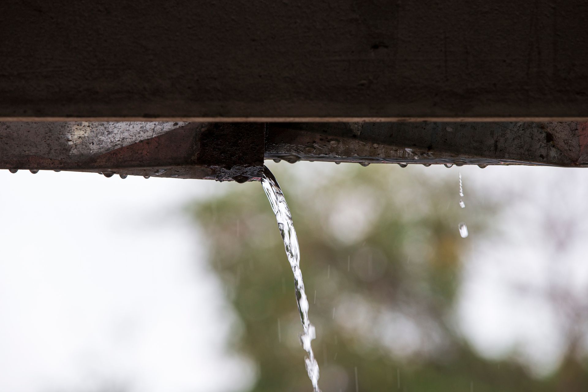 water dripping from a cracked gutter.