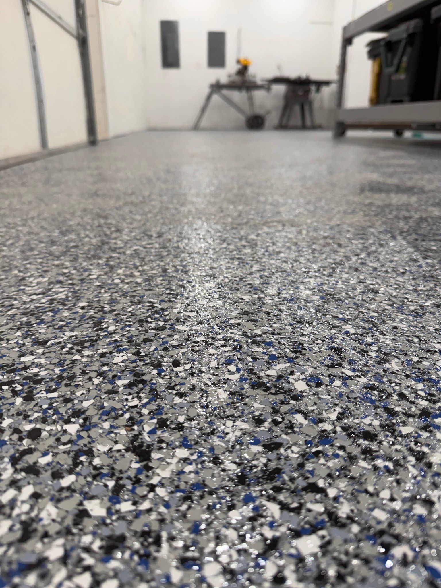Speckled epoxy garage floor with a blurred workbench in the background