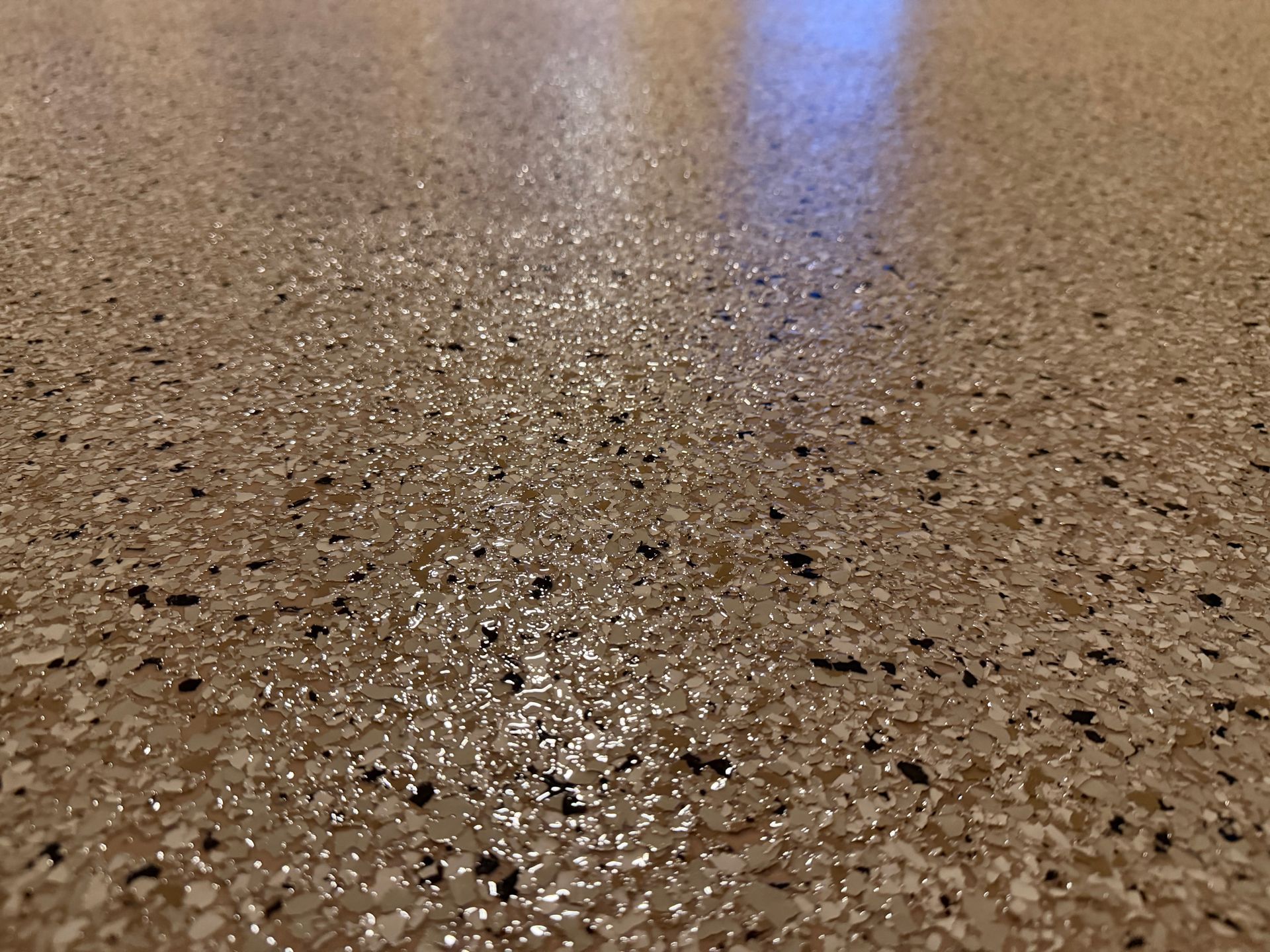 Speckled brown polished floor with soft reflections of blue light
