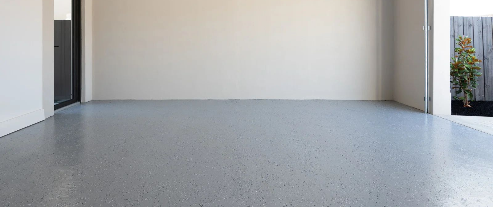 Empty modern porch with light gray speckled floor and white walls