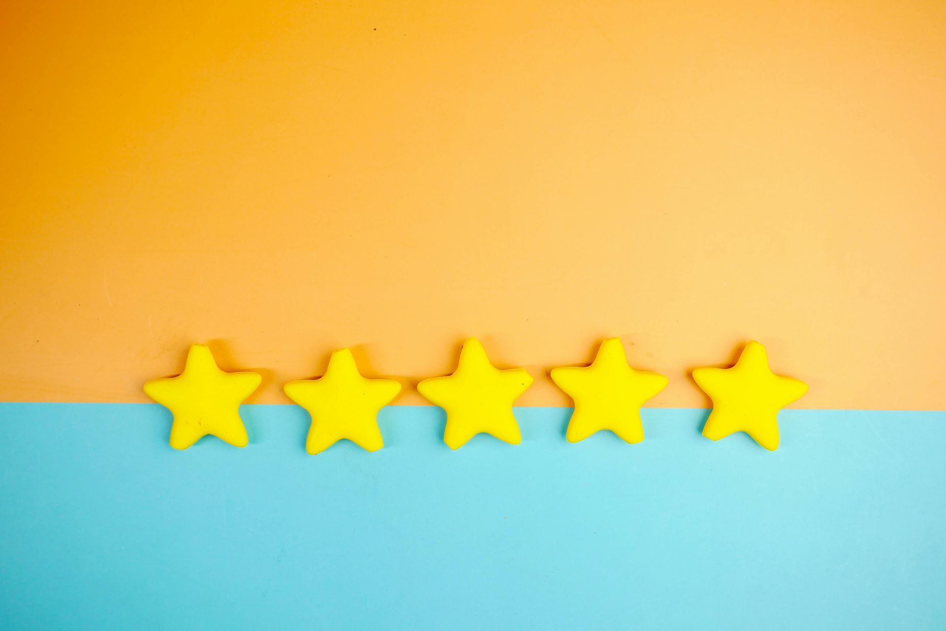 Five yellow star shapes arranged in a horizontal row against a split orange and blue background.