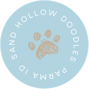 Light blue circular logo with white text and a tan paw print in the center