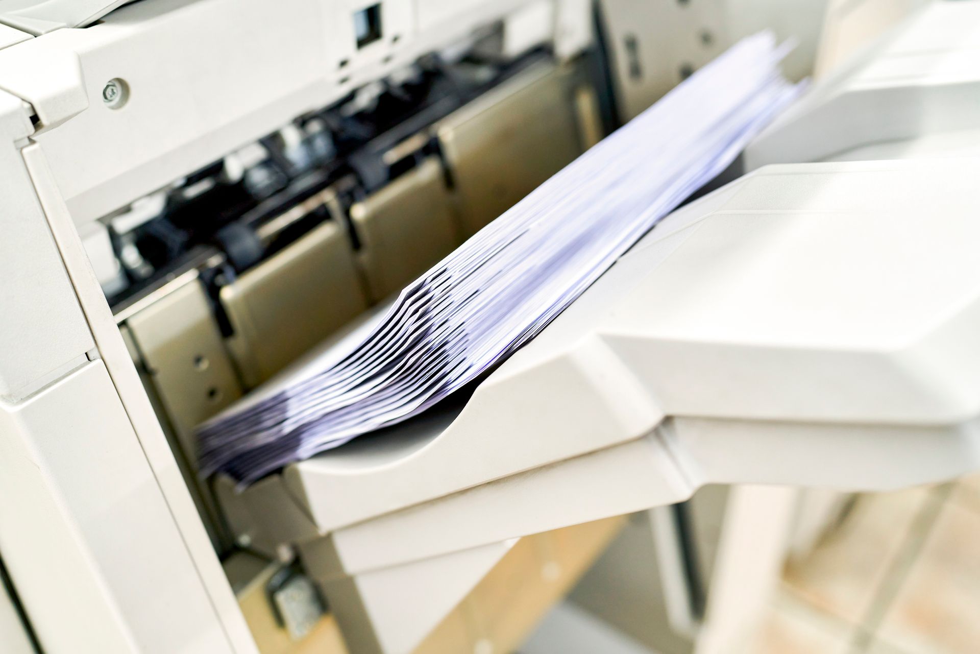 A stack of paper is coming out of a printer.