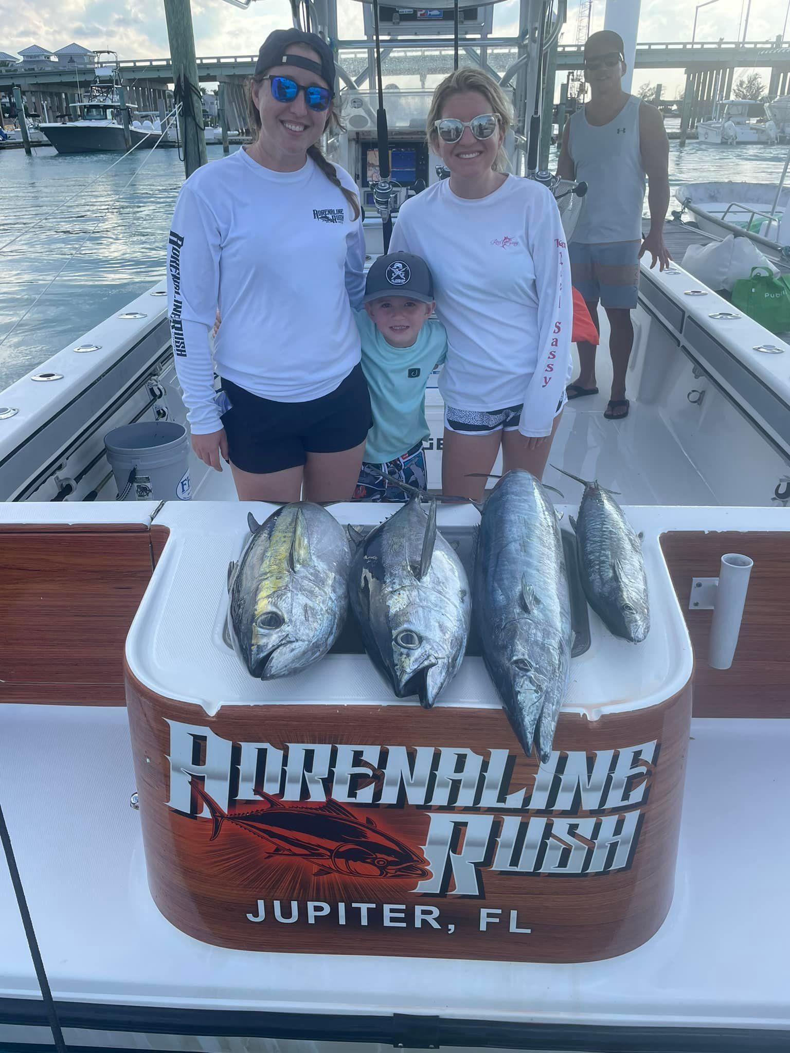 Two anglers pose with a dolphin fish catch aboard a boat marked “Reel N Chill Fish,” Jupiter, FL
