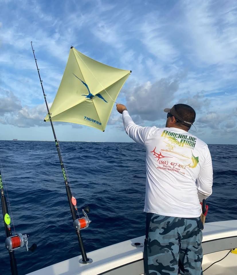 Angler on a boat releases a yellow kite into the windy ocean sky.