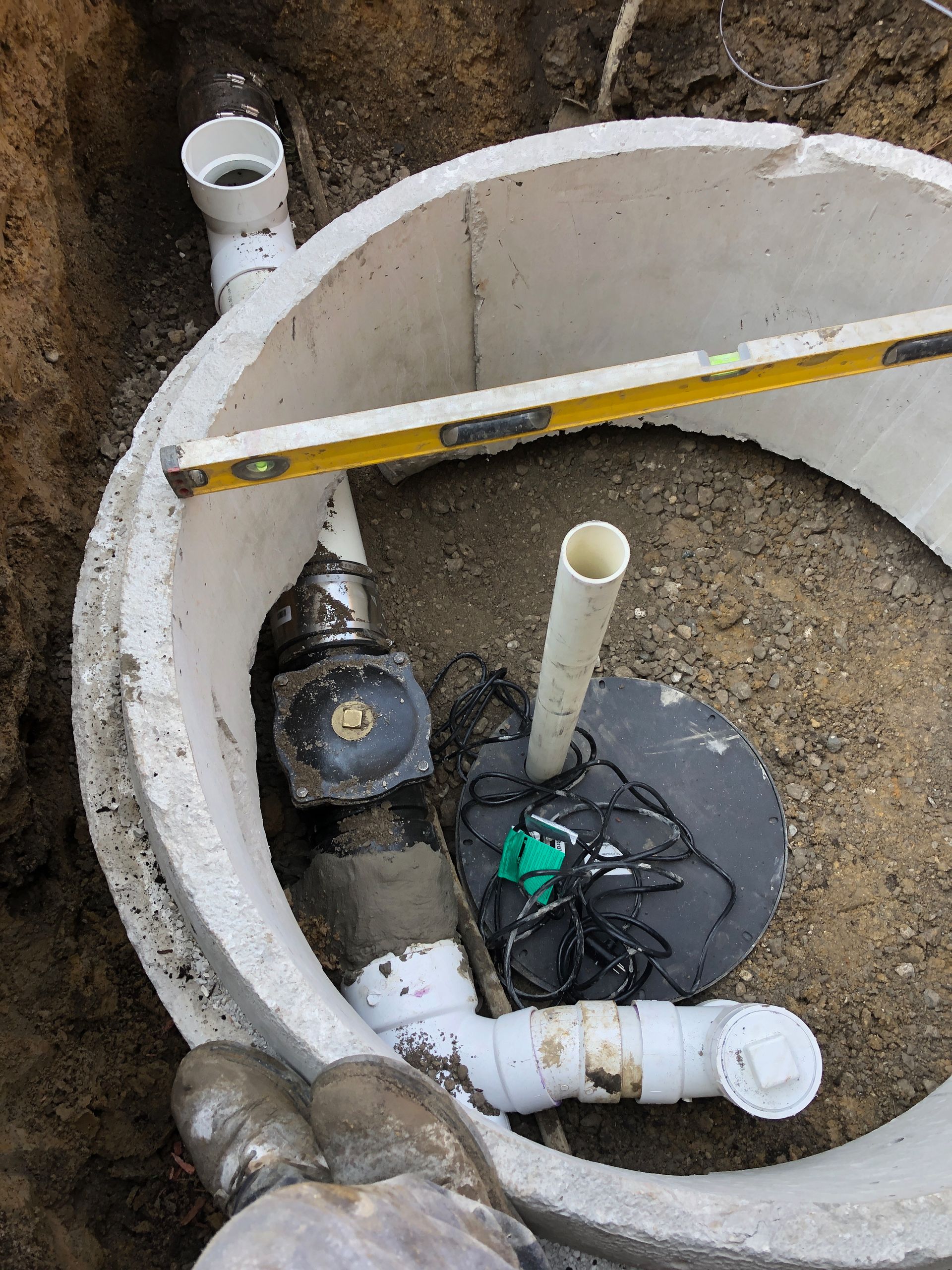 PLACEHOLDER — replace with H2O technician servicing an ejector pump in a basement utility room.