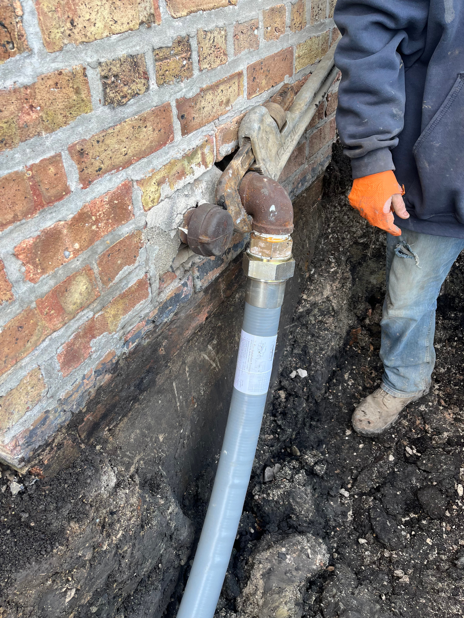 PLACEHOLDER — replace with H2O technician inspecting or replacing a lead water service line at a residential property, close-up of pipe work, natural light.