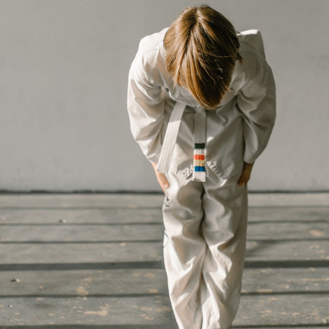 a person in a white karate uniform with a red white and blue belt