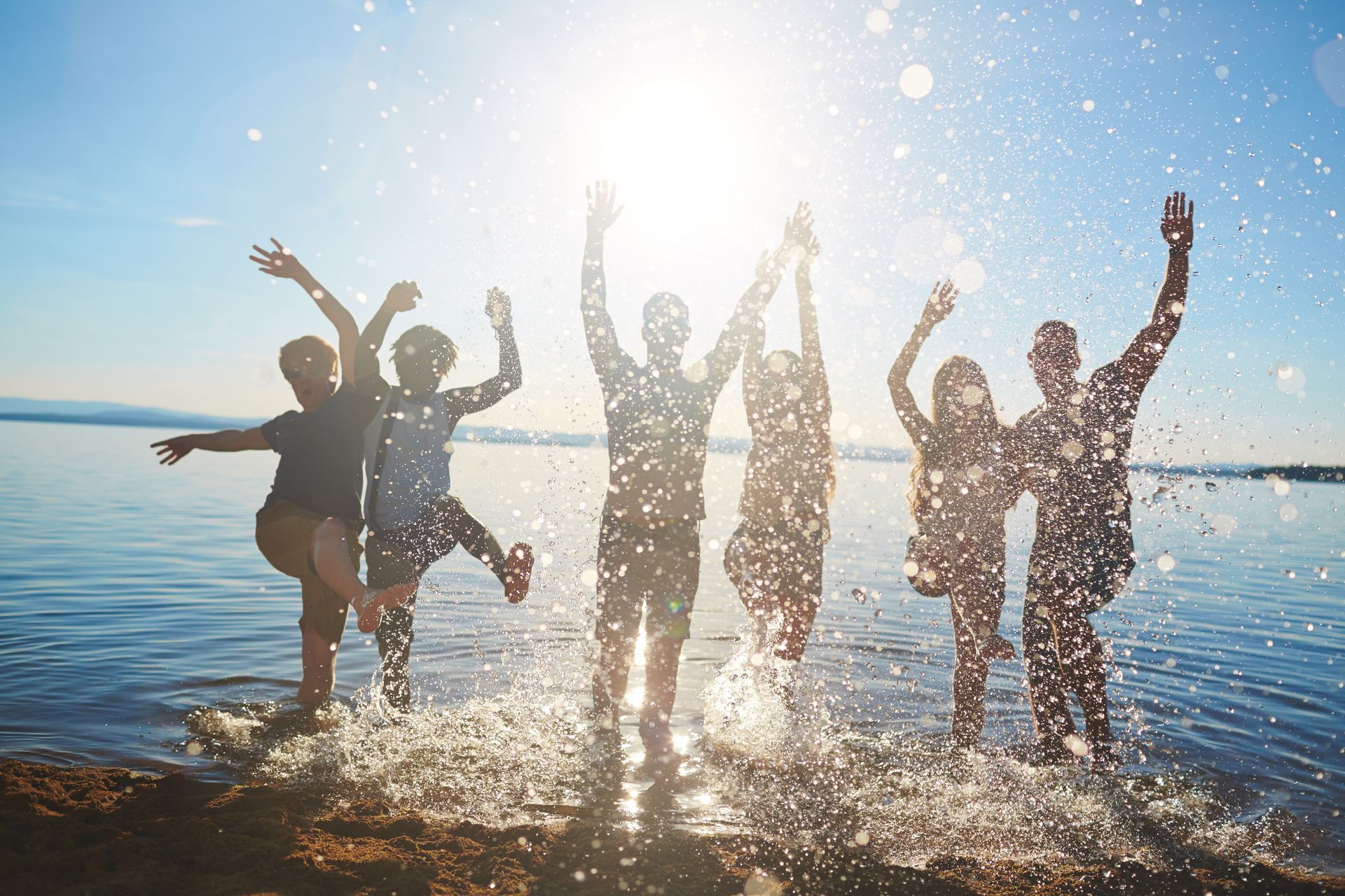 group of friends enjoying the outdoors - jumping in lake group of friends enjoying the outdoors - jumping in lake