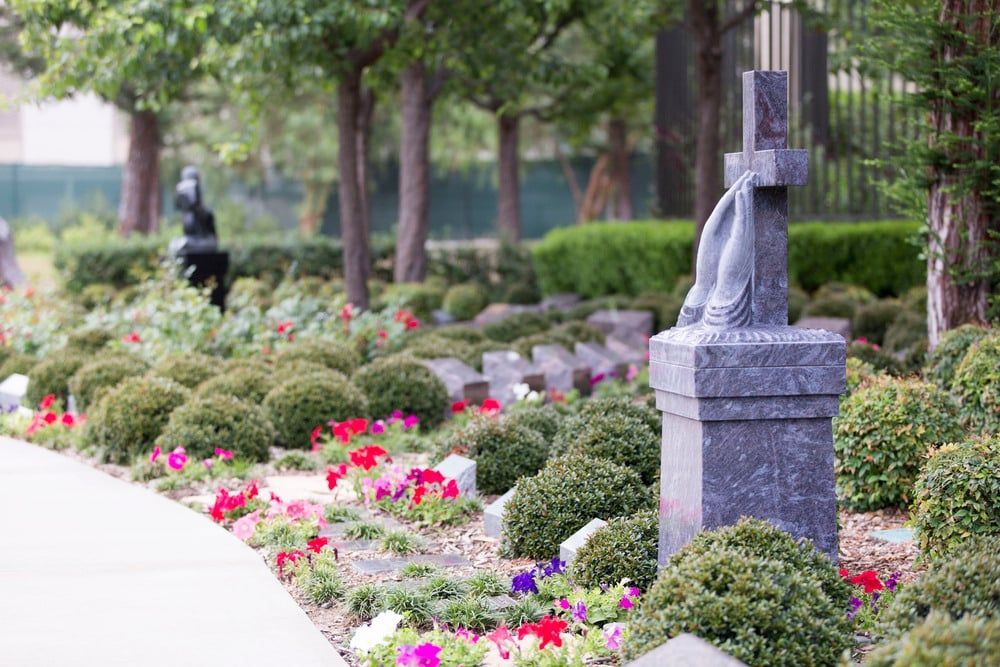 Garden path with colorful flowers, manicured shrubs, and a stone lantern in a park