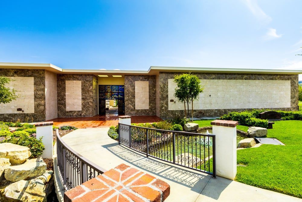 Modern house exterior with curved brick walkway, front lawn, and landscaped garden