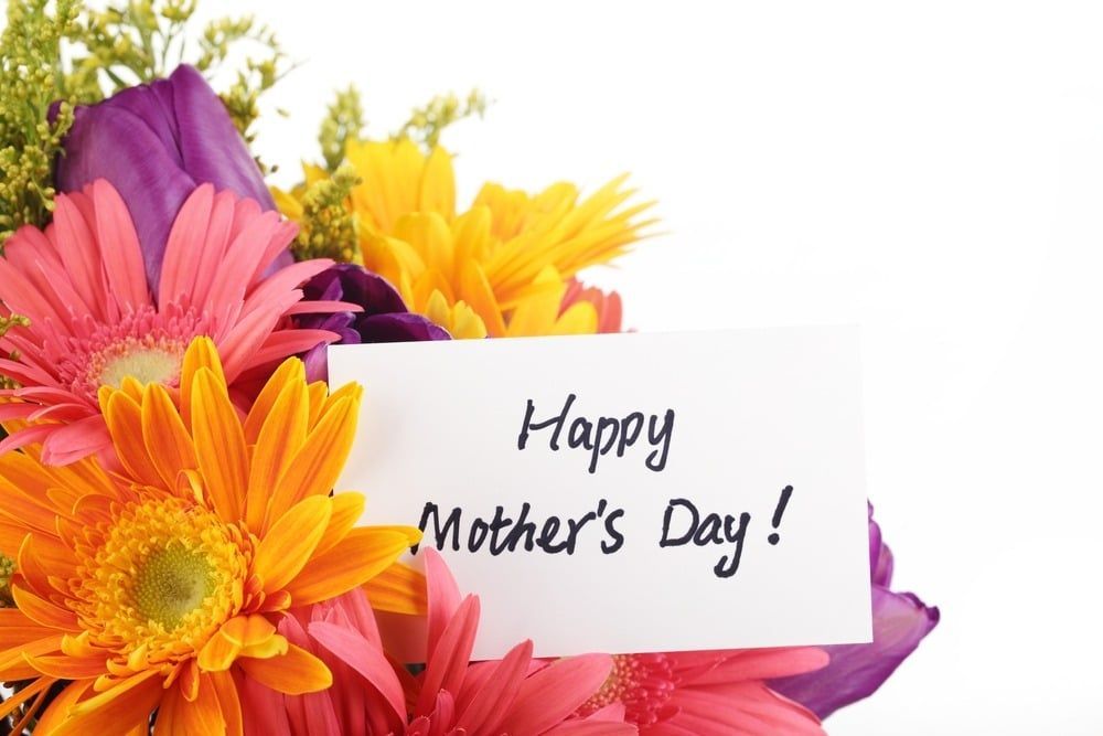 Colorful flowers surrounding a card that says “Happy Mother’s Day!”