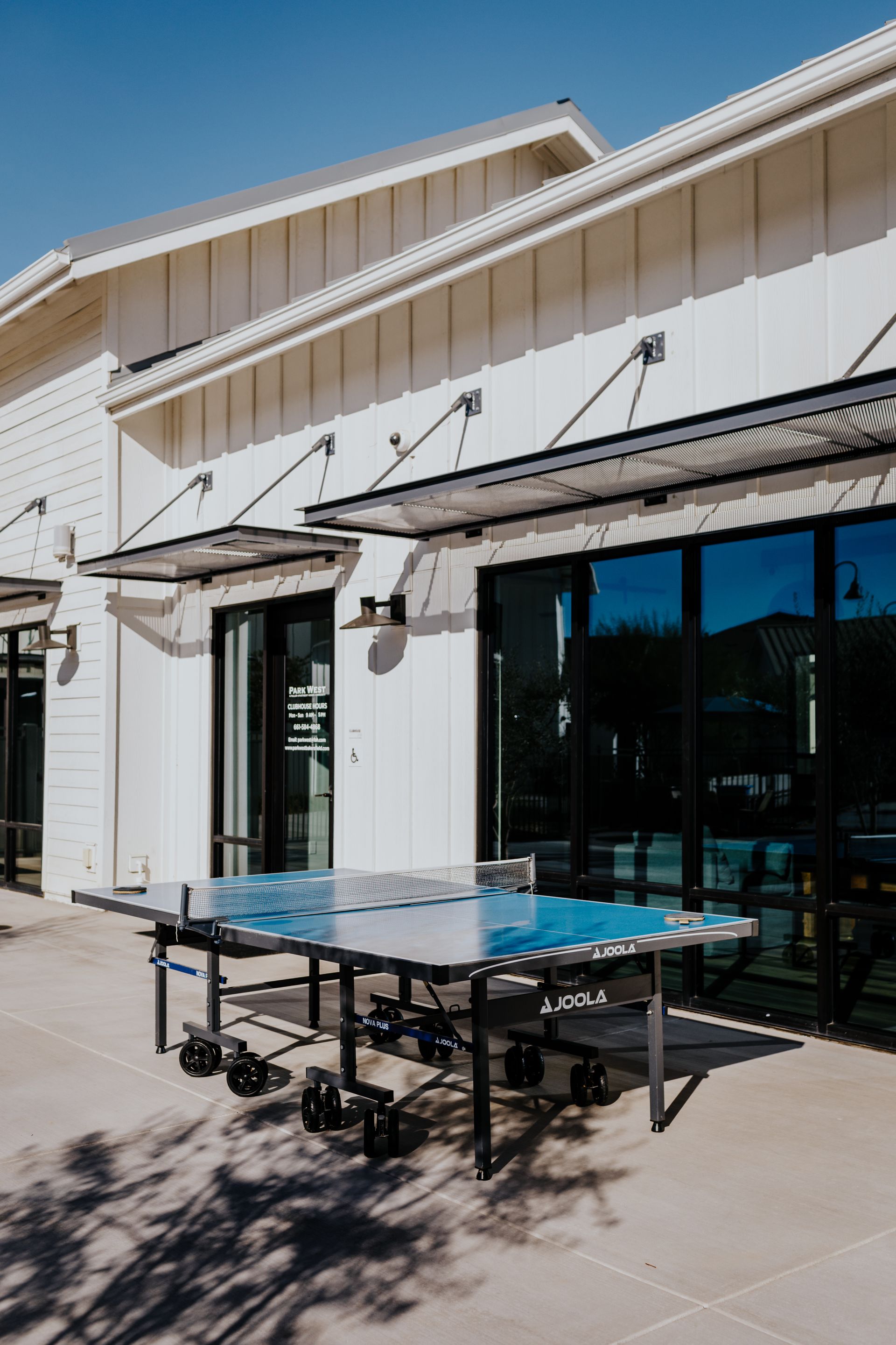 A ping pong table is sitting outside of a building.