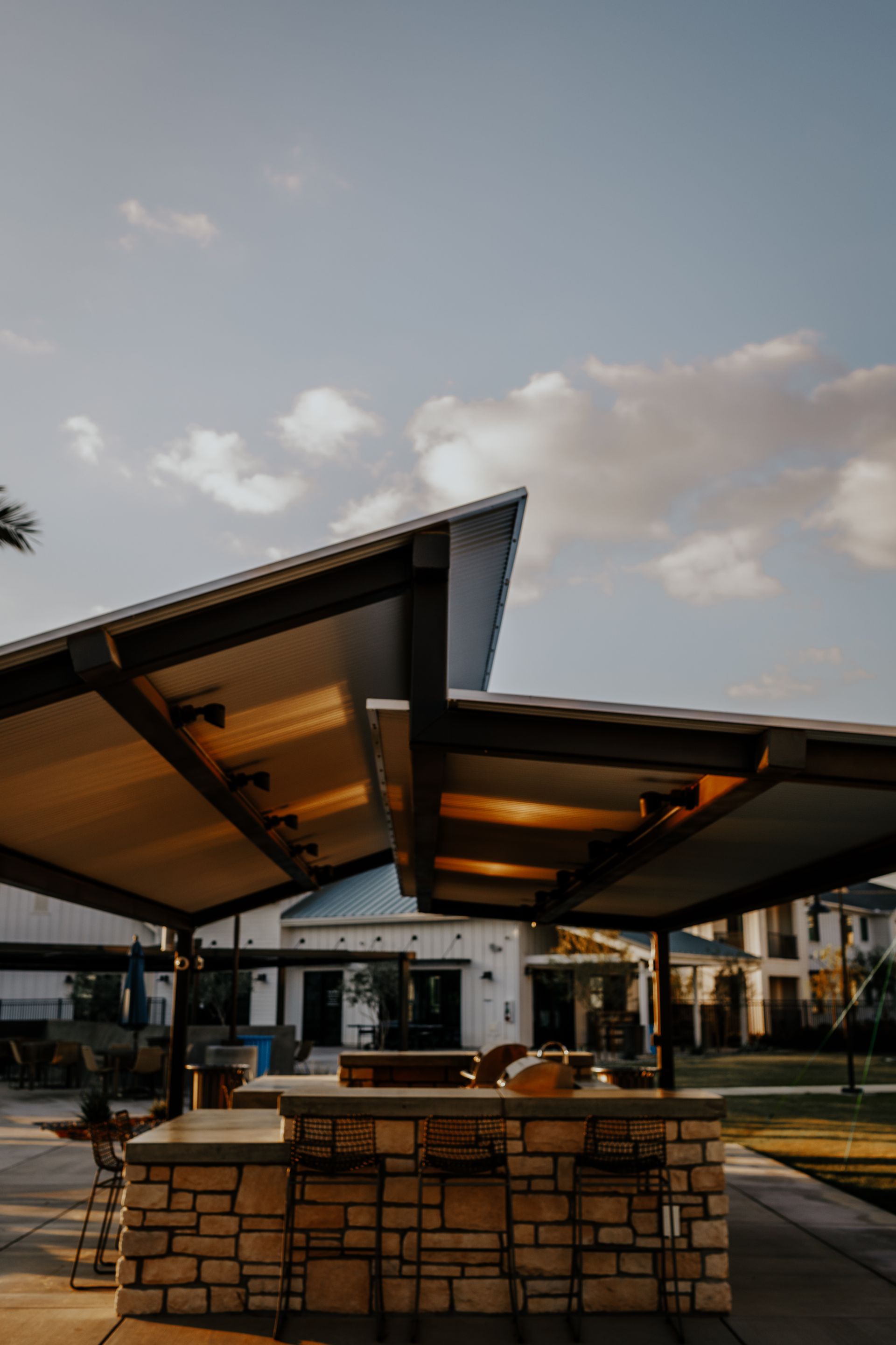 A patio area with a bar and chairs under a canopy.
