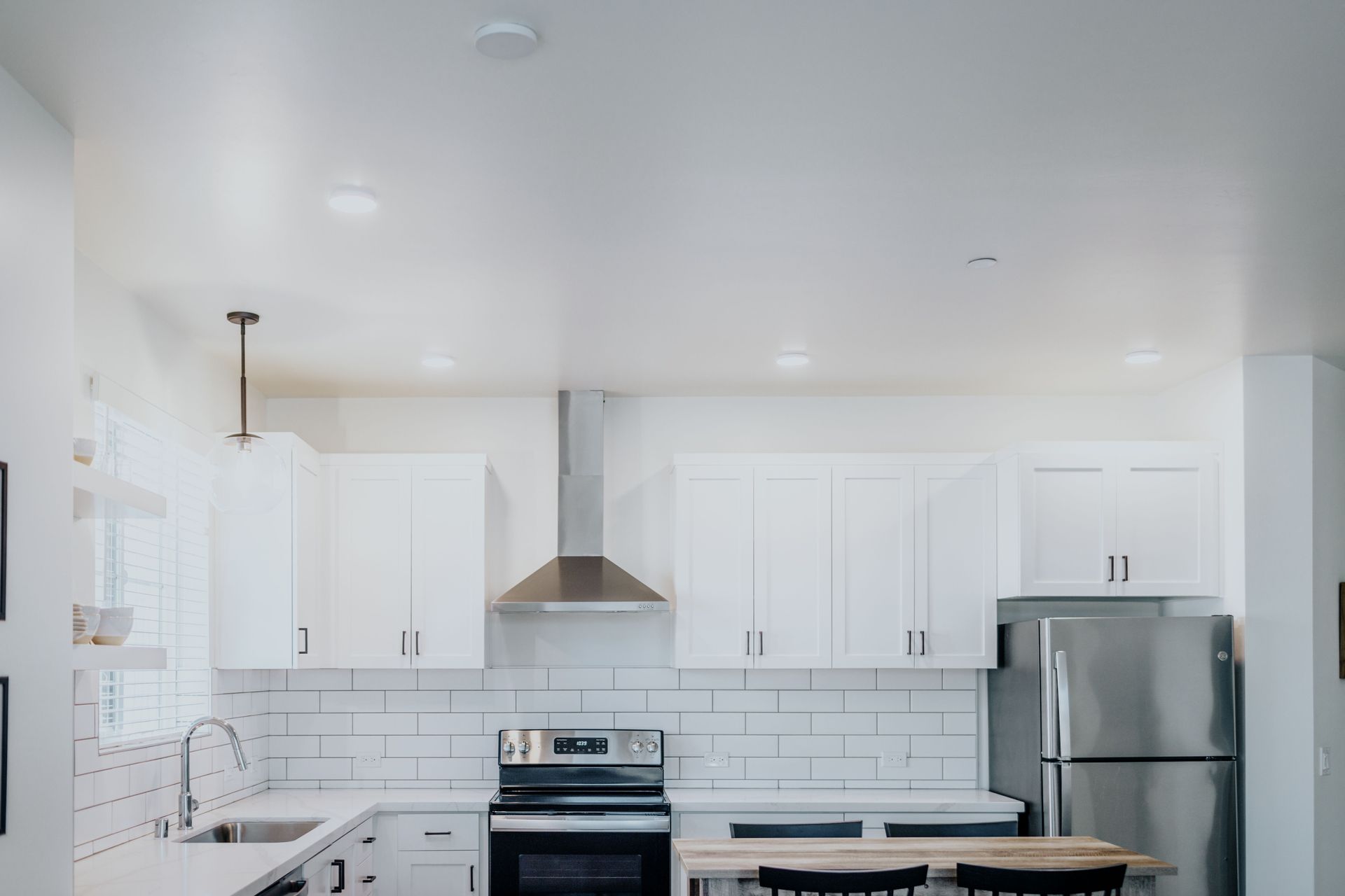 two bedroom kitchen with stainless steel fridge, stove, hood range, dishwasher
