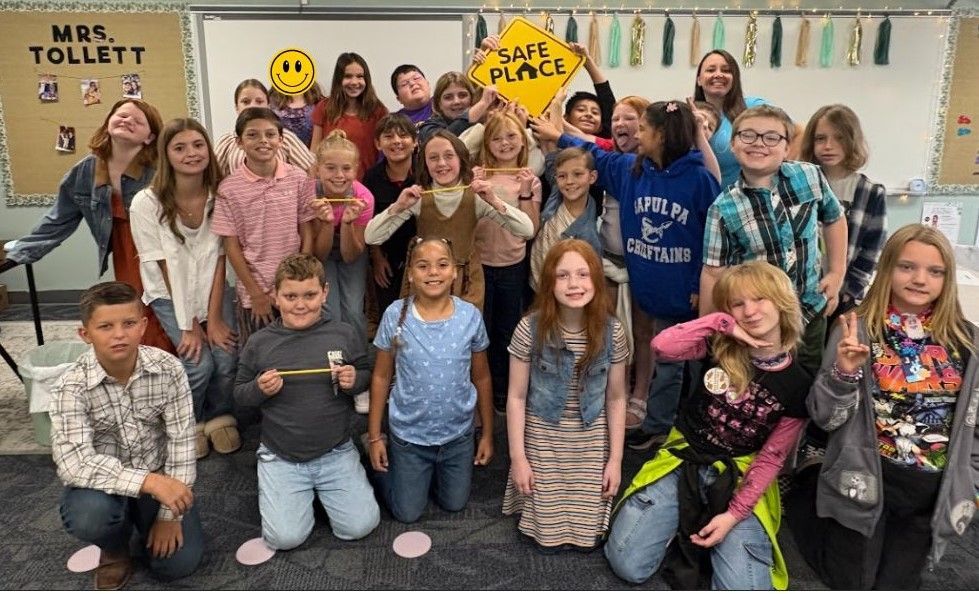 Group of students in a classroom, some holding a