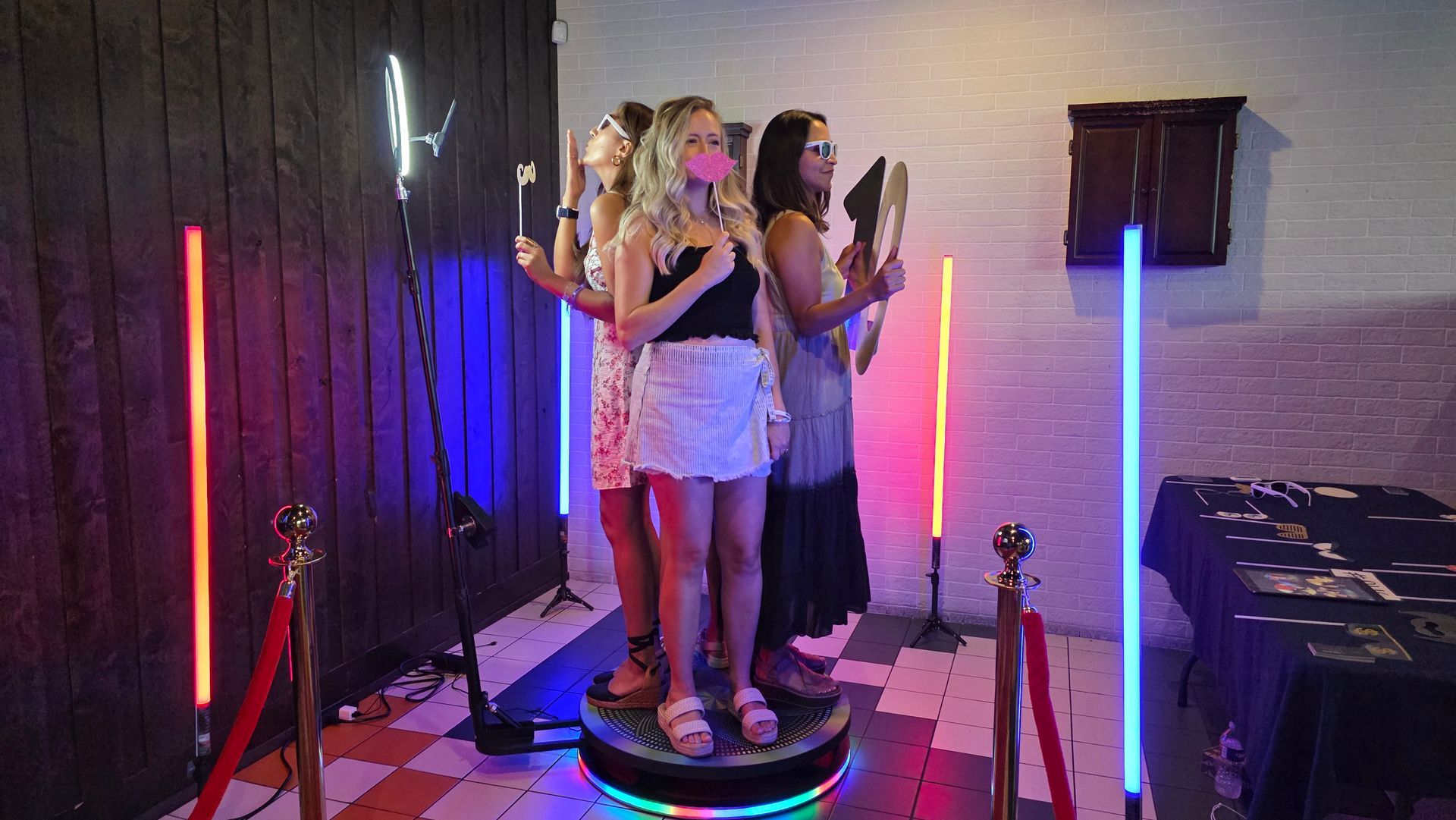 Guests posing on the 360 photo booth platform with LED lighting at a corporate event organized for 