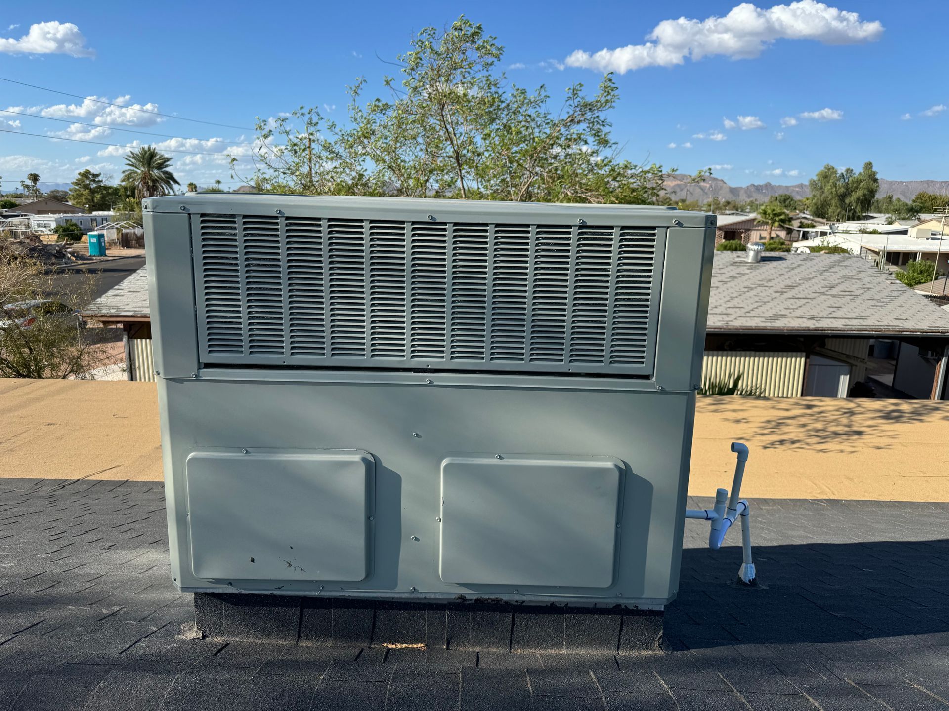 A large air conditioner is sitting on top of a roof.