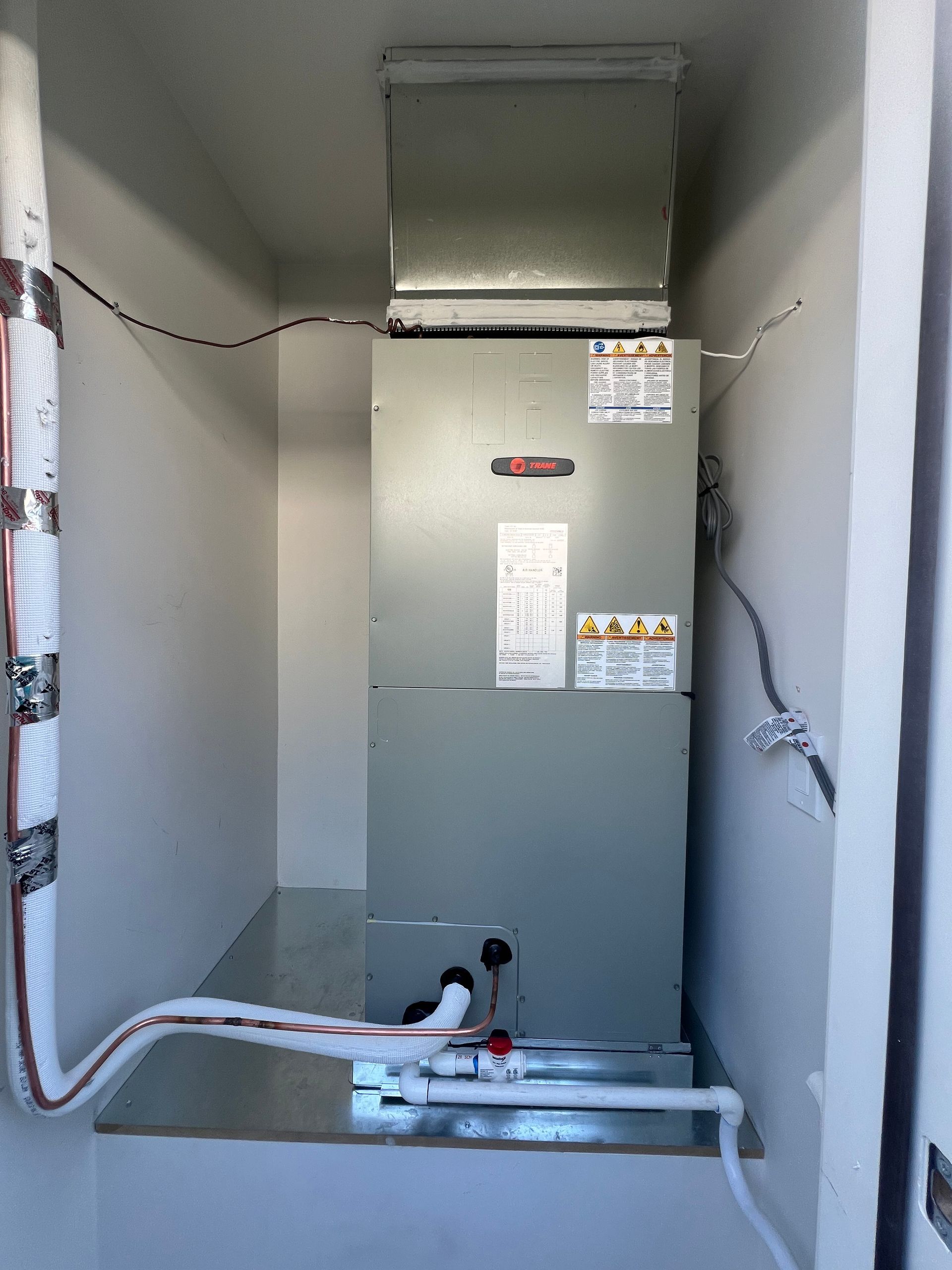 A room with a heater and pipes coming out of it.