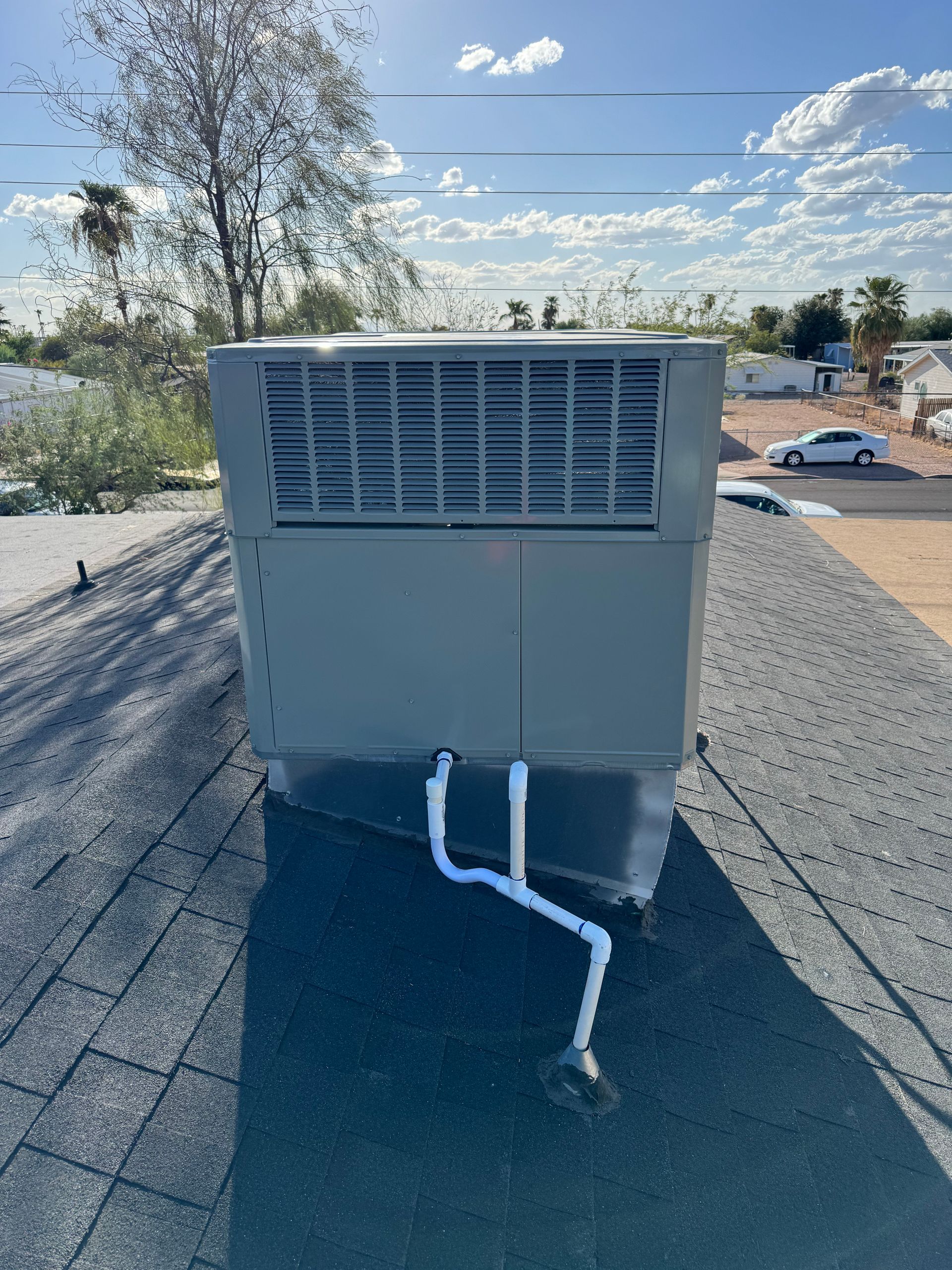 A large air conditioner is sitting on top of a roof.